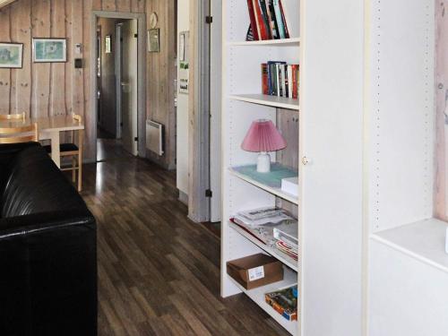a living room with a book shelf with a lamp at Cozy Retreat with Spa - By Traum Ferienwohnungen in Sarup
