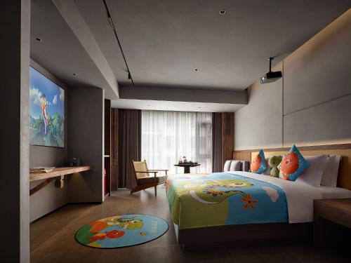 a hotel room with a bed and a desk and a room at Zhangjiajie SANHE Hotel --Free one way pick up service over 2 night, Free shuttle to east gate of forest park,Free laundry service,Free fresh coffee,English speaking customer service in Zhangjiajie