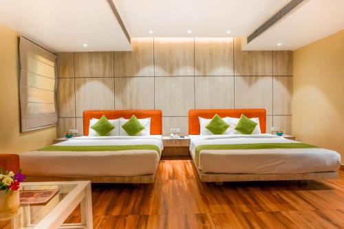 two beds in a room with wooden floors at Stamps Golden Lagoon by Eight Continents - Opposite to Golden Temple in Amritsar