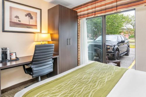 a hotel room with a bed and a desk and a window at Comfort Inn in Chatham