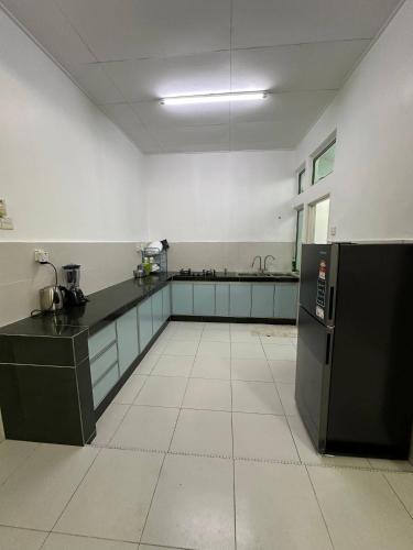 a large kitchen with a black counter and appliances at MITC Comfort Stay in Malacca
