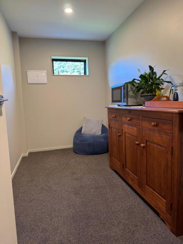 a room with a cabinet with a microwave and a chair at Walnut Creek Studio in West Melton