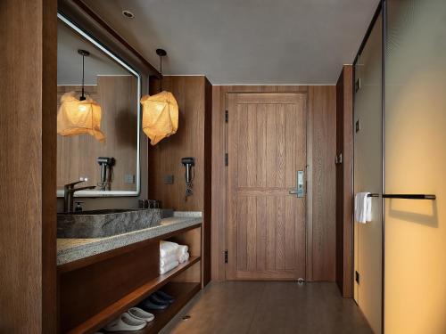 a bathroom with a sink and a mirror at Zhangjiajie SANHE Hotel --Free one way pick up service over 2 night, Free shuttle to east gate of forest park,Free laundry service,Free fresh coffee,English speaking customer service in Zhangjiajie