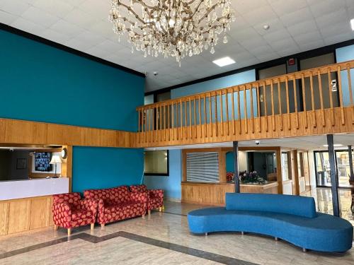 a lobby with blue and red furniture and a chandelier at Rodeway Inn in Bloomington