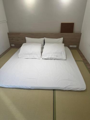 a large bed with white sheets and pillows on it at DayBreak 2 in Taitung City