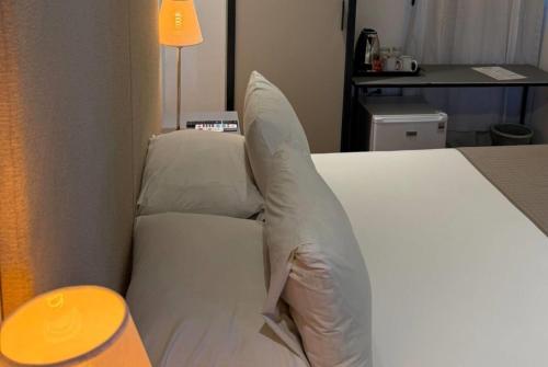 a bed with white pillows in a hotel room at Esplendor by Wyndham Montevideo Cervantes in Montevideo