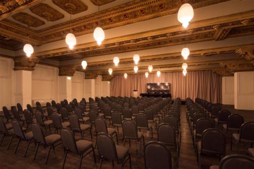an empty room with chairs and a stage in it at Esplendor by Wyndham Montevideo Cervantes in Montevideo