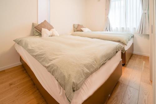 two beds sitting next to each other in a bedroom at 全新三之轮一户建b栋 in Tokyo