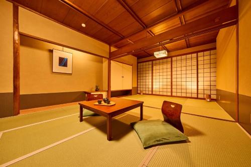 a room with a table and a chair in it at Ooedo Onsen Monogatari Yamashiro Saichoraku in Kaga