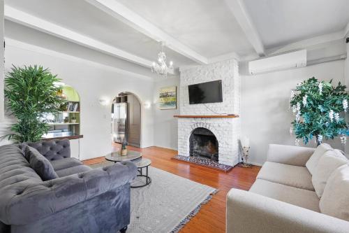 a living room with two couches and a fireplace at Central Epsom Retreat in Auckland