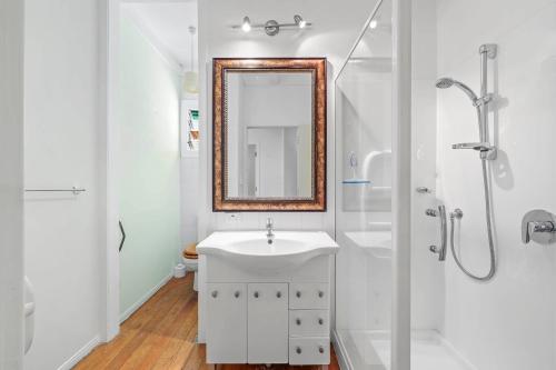 a white bathroom with a sink and a shower at Central Epsom Retreat in Auckland