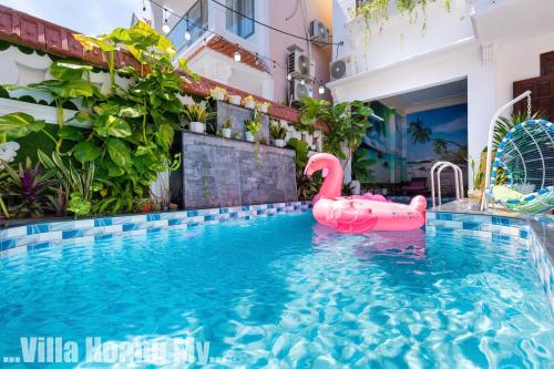 a swimming pool with a pink swan in the water at Biệt Thự Hồ Bơi Nguyên Căn Free Sub Và Xe Máy in Vung Tau
