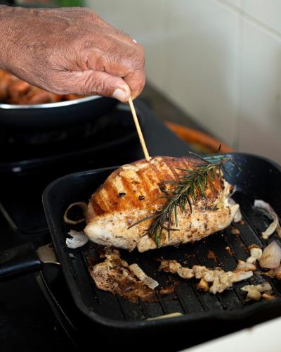 a person is cooking a piece of food on a grill at Kirindi Paddy Isle in Negombo