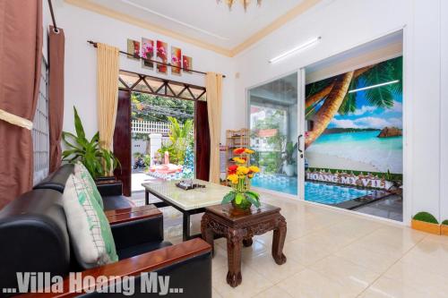 a living room with a couch and a table at Biệt Thự Hồ Bơi Nguyên Căn Free Sub Và Xe Máy in Vung Tau