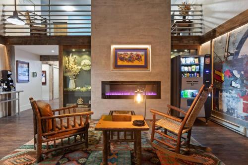 a lobby with two chairs and a table and a fireplace at Days Inn and Suites by Wyndham Downtown Missoula-University in Missoula
