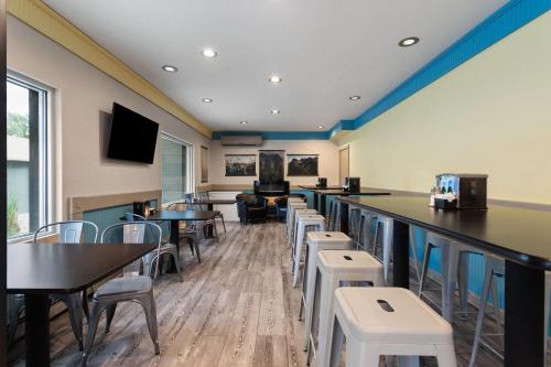 ein Restaurant mit Tischen und Stühlen und eine Bar in der Unterkunft Days Inn and Suites by Wyndham Downtown Missoula-University in Missoula