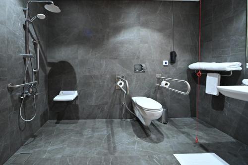 a bathroom with a toilet and a sink and a shower at Clarion Hotel Jeddah Airport in Jeddah