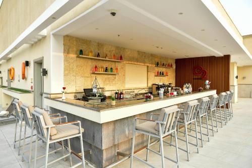 a bar in a restaurant with a row of chairs at Clarion Hotel Jeddah Airport in Jeddah