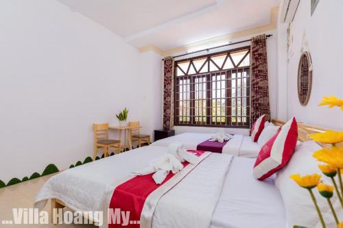a bedroom with a large bed with red and white sheets at Biệt Thự Hồ Bơi Nguyên Căn Free Sub Và Xe Máy in Vung Tau