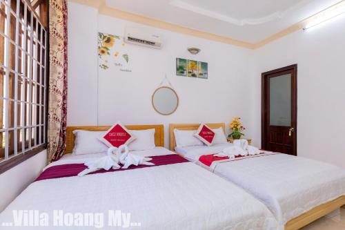 two beds in a room with white walls at Biệt Thự Hồ Bơi Nguyên Căn Free Sub Và Xe Máy in Vung Tau