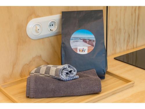 Una toalla sobre un suelo de madera junto a una bolsa. en Tiny House in Zeeland near Oranjezon Dunes, en Vrouwenpolder