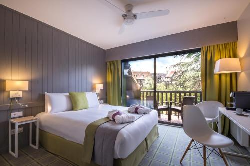 a hotel room with a bed and a balcony at Mercure Deauville Centre in Deauville