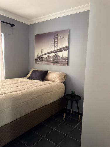 a bedroom with a bed with a picture of a bridge at Prime 3bedroom Guest & Self-Catering Accomodation in Windhoek