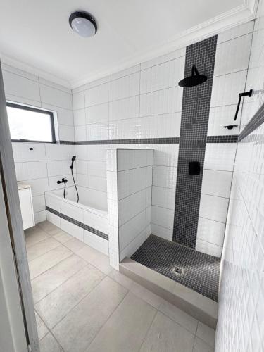 a bathroom with a shower and a bath tub at Prime 3bedroom Guest & Self-Catering Accomodation in Windhoek