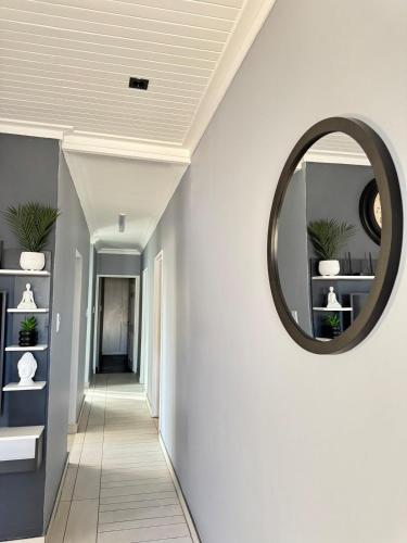 a hallway with a round mirror on the wall at Prime 3bedroom Guest & Self-Catering Accomodation in Windhoek