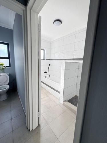 a bathroom with a tub and a toilet in it at Prime 3bedroom Guest & Self-Catering Accomodation in Windhoek