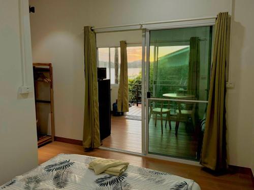 una camera da letto con un letto e una porta scorrevole in vetro di Colibri Beach Resort a Ban Chalok Lam