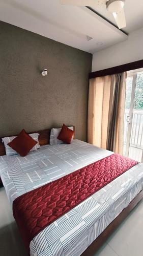a large bed with red pillows in a bedroom at Nelleri Residency Managed By Vaishno Hospitality in Iritti