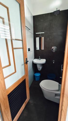 a bathroom with a toilet and a sink at Nelleri Residency Managed By Vaishno Hospitality in Iritti