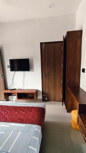 a bedroom with a bed and a flat screen tv at Nelleri Residency Managed By Vaishno Hospitality in Iritti