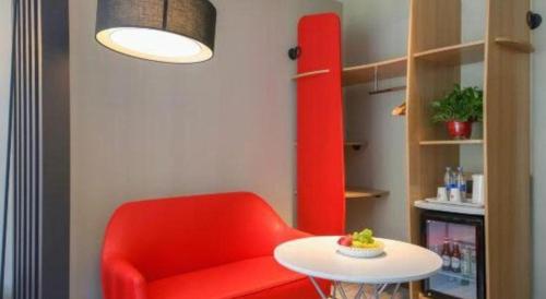 a red chair and a table in a room at ibis xian North Second Ring Weiyang Rd Hotel in Xi'an