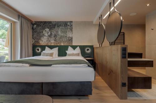 a bedroom with a large bed and a staircase at Ferienhotel Jörglerhof in Hainzenberg