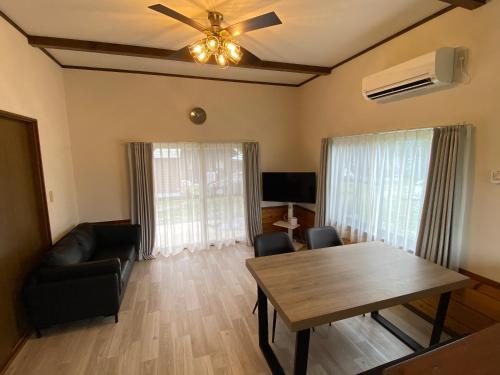 a living room with a table and a couch at 天然プラネタリウムcottage星空A棟 in Nasushiobara