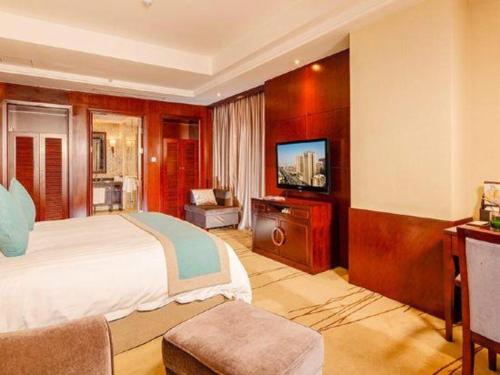 a hotel room with a bed and a television at Gaosu New Century Hotel International Anhui in Hefei
