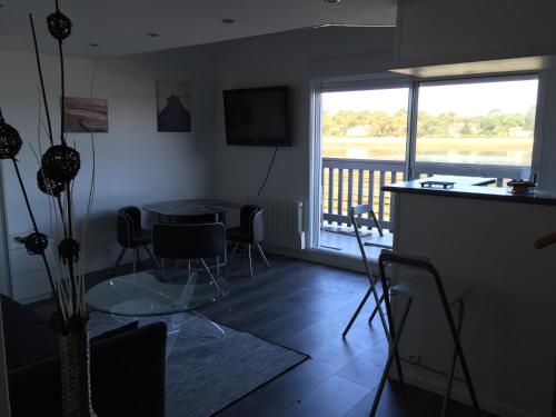 a living room with a table and chairs and a balcony at Appartement Du Lac in Hossegor