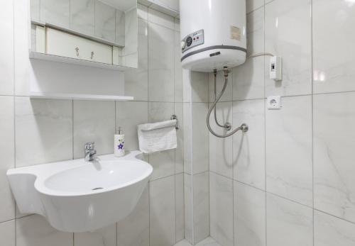 a white bathroom with a sink and a shower at Sultan Apartments in Istanbul