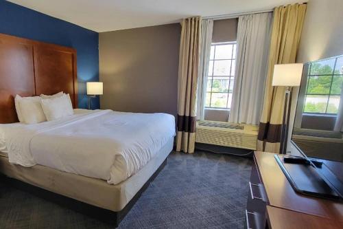 a hotel room with a large bed and a desk at Comfort Inn Bessemer Birmingham South in Bessemer
