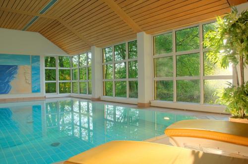a large swimming pool with windows in a house at Heilbad Krumbad in Krumbach