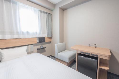 a room with a bed and a desk and a chair at Washington R&B Hotel Nagoya Sakae Higashi in Nagoya