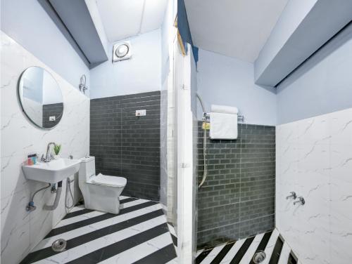 bagno con lavabo, servizi igienici e specchio di Hotel ALLEN STAY Uttam Nagar a Nuova Delhi
