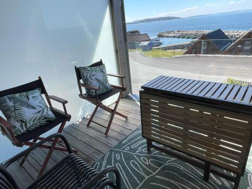 two chairs and a table on a porch with a view of the ocean at Haabakk on Sea in Tau