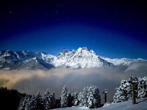 a snow covered mountain with trees in the foreground at Berggasthaus Eggberge - Boutique Mountain Hotel - Access via Cablecar in Altdorf