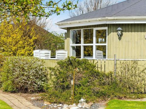 a house with two white chairs on the porch at 4 person holiday home in Vinderup-By Traum in Vinderup