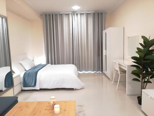 a white bedroom with a bed and a desk at Quickstay holiday homes Stylish Studio Silicon Oasis-124 in Dubai