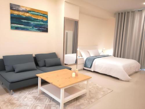 a bedroom with a bed and a couch and a table at Quickstay holiday homes Stylish Studio Silicon Oasis-124 in Dubai