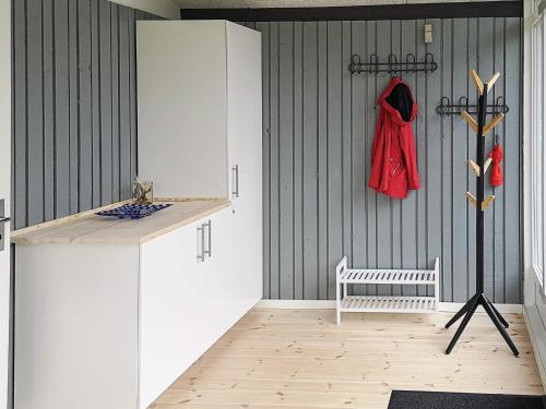 a kitchen with white cabinets and a red coat on the wall at 10 person holiday home in Højslev-By Traum in Lund